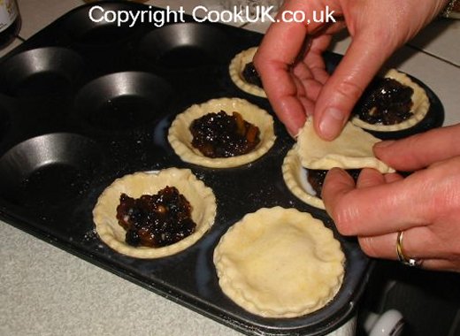 Mince pies being covered with shortcrust pastry