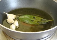Infusing olive oil with garlic and a bay leaf