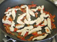 Frying sweet red peppers and chicken